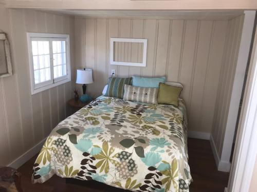 a bedroom with a bed with a floral comforter at Lakeshore Fishing Cabin #3, Ramp, dock, fire pit in Lake Ozark