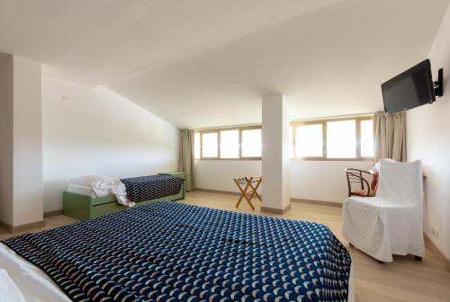 a bedroom with a bed and a tv on the wall at Hotel Cavallino Bianco in Cavallino-Treporti