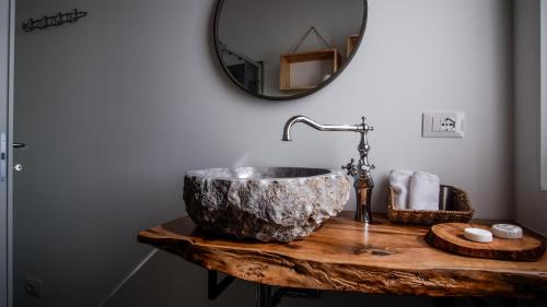 W łazience znajduje się kamienna umywalka i lustro. w obiekcie Ca di Timo B&B w mieście Salionze