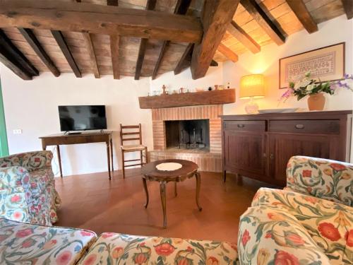 a living room with a couch and a fireplace at La Ginestra - Terrazza in Orciatico
