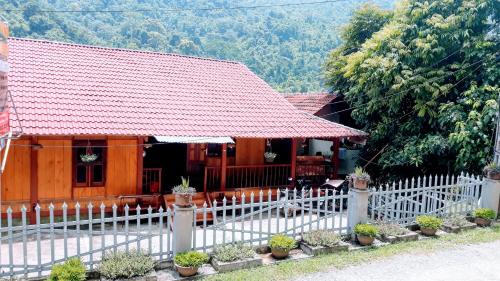 a white fence in front of a house at Nam Pé Tày Homestay - View hồ Ba Bể in Bak Kan