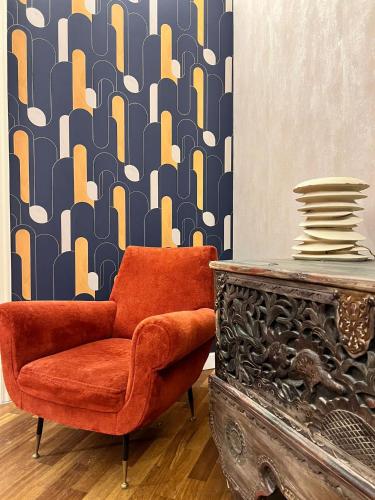 a orange chair sitting next to a table in a room at B&B La Cuntana in Potenza