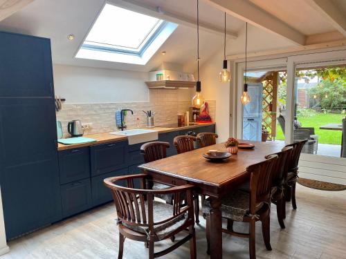 a kitchen with a wooden table and some chairs at Huisje Achterom in Thorn