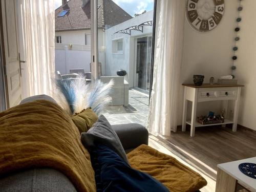 a living room with a couch and a clock on the wall at Les pieds dans l'eau... au chaud !!! in Le Crotoy