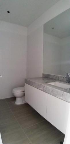 a bathroom with a toilet and a sink and a mirror at Vive - Descansa - Disfruta in San Bartolo