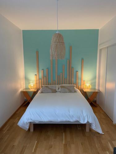- une chambre avec un lit blanc et un mur bleu dans l'établissement Très bel appartement vue Mer - Les Ilots bleus - Dunkerque Malo les Bains, à Dunkerque