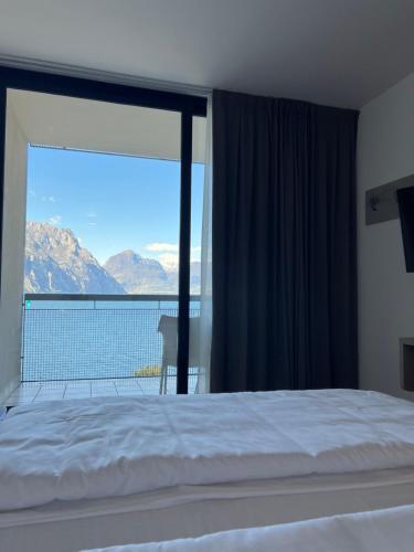 a bedroom with a bed and a view of the ocean at Wind Hotel in Malcesine