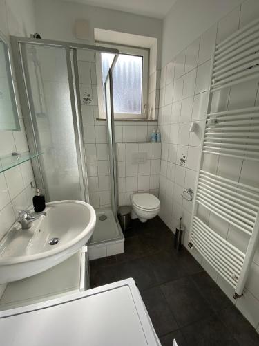 a white bathroom with a sink and a toilet at Apartment an der Weserpromenade - Schlachte - Parkplätze in Bremen