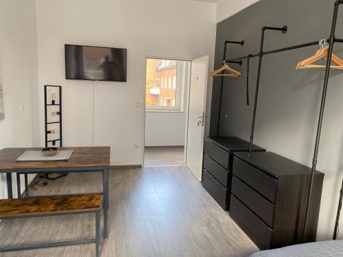 um quarto com uma secretária, uma cama e uma televisão em Apartment an der Weserpromenade - Schlachte - Parkplätze em Bremen