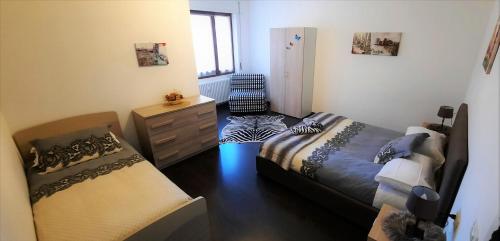 ティラーノにあるLucini Ai Porticiのベッドルーム1室(ベッド2台、ドレッサー、椅子付)