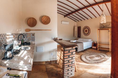 een keuken met een wastafel en een bed in een kamer bij Vila Castanheiras in Barra Grande