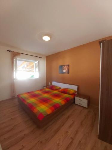- une chambre avec un lit et une couverture colorée dans l'établissement APARTMANI LANA, à Rab