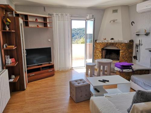 a living room with a couch and a fireplace at Family Deluxe Apartment Mirjana in Kampor