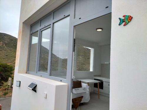 une chambre avec une grande fenêtre dans une maison dans l'établissement Loft con piscina comunitaria, à Las Negras