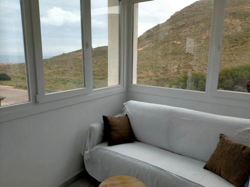 - un canapé blanc dans une pièce avec fenêtres dans l'établissement Loft con piscina comunitaria, à Las Negras