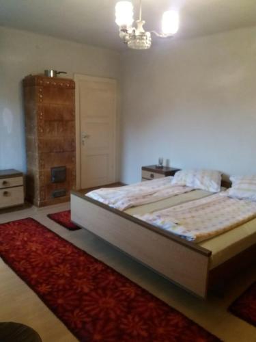 a bedroom with a large bed and a red rug at Guest House - Wai derhim in Sibiu