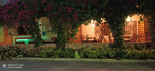 a patio with purple flowers and a table and chairs at Hosteria B y B in Tonsupa