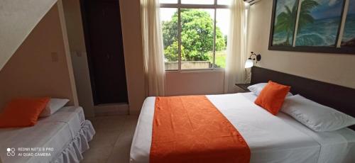 a bedroom with two beds and a window at Hosteria B y B in Tonsupa