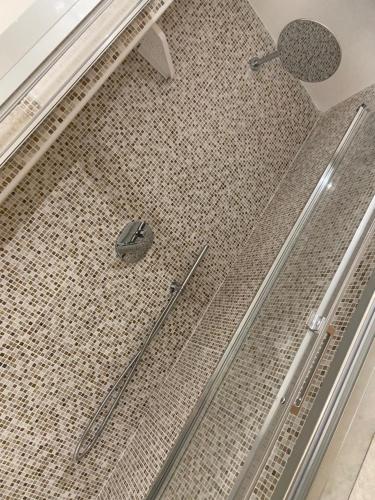 um chuveiro com piso em azulejo e um chuveiro. em L'angolo di Costalpino em Siena