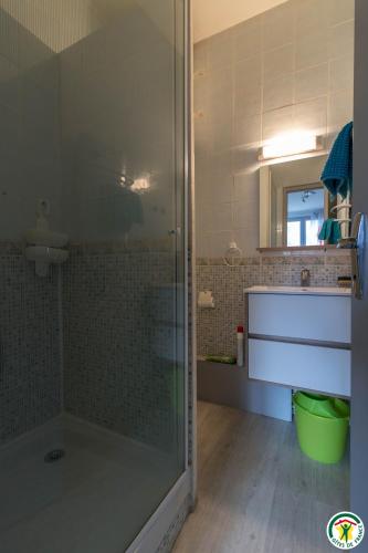 une salle de bain avec une douche avec une porte vitrée dans l'établissement Appart Luchon au centre des allée d'etigny, à Luchon