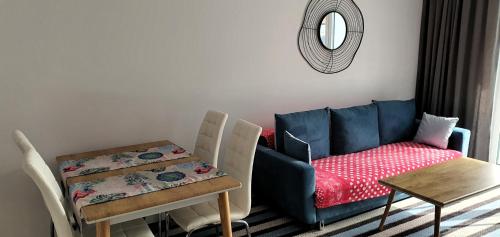 un soggiorno con un divano blu e un tavolo di Apartament Bel Mare a Międzyzdroje