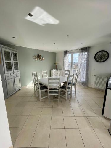 une salle à manger avec une table et des chaises blanches dans l'établissement Face Chateau de Chaumont sur loire Gîte La Rapinière, à Onzain