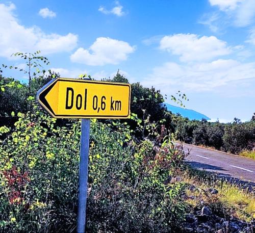 a yellow road sign on the side of a road at Merlo House Dol Hvar in Stari Grad