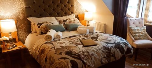 a bedroom with a large bed and a chair at Outlander Boutique B&B King in Cruden Bay