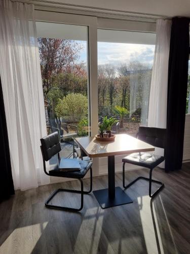 a table and two chairs in a room with a large window at Tip Top Studio Vlissingen in Vlissingen
