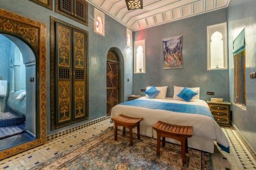 a bedroom with a bed and two chairs in it at Riad AZARO in Marrakesh