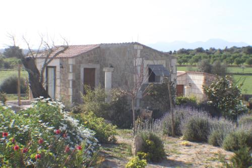 a stone house with a garden in front of it at Agroturisme Es Racó De Maria in Maria de la Salut