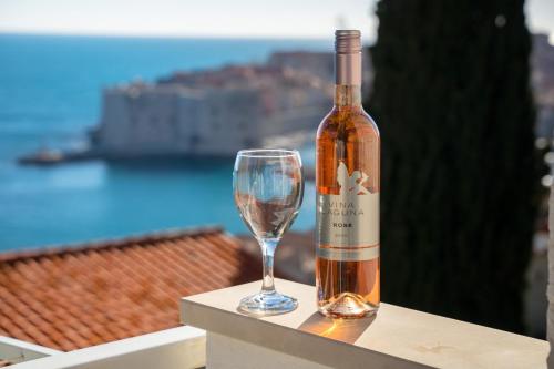 una botella de vino junto a una copa de vino en Apartments Banje Beach, en Dubrovnik