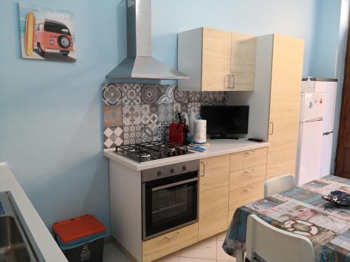 a kitchen with a stove top oven next to a table at Short Lets Vacanze "Massimo" in Trappeto