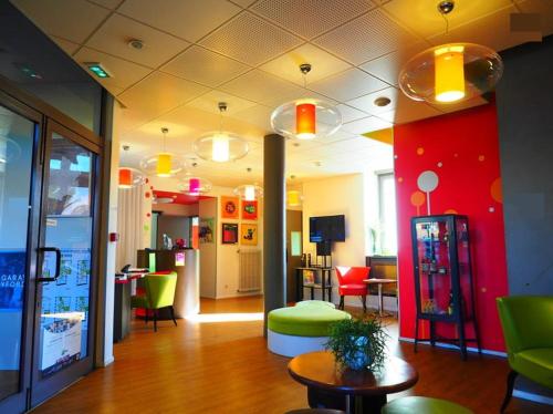 eine Lobby eines Ladens mit bunten Stühlen und einem Tisch in der Unterkunft ibis Styles Saint Brieuc Gare Centre in Saint-Brieuc