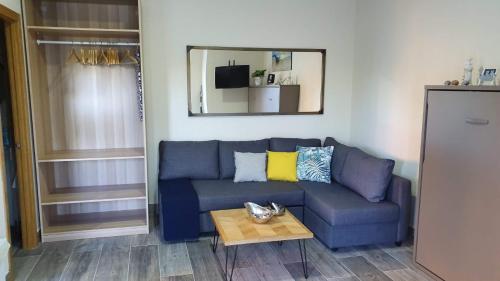 a blue couch in a living room with a table at Apartamento Marina el Puerto in El Puerto de Santa María