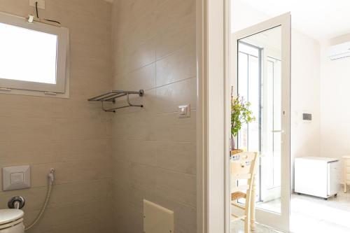 a bathroom with a shower and a toilet at SalentOspita Guest Rooms in Torre San Giovanni Ugento