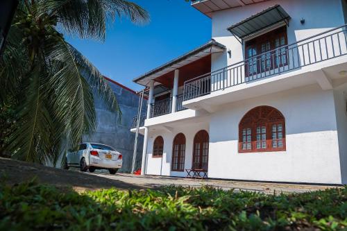 a white car parked in front of a building at Lakeside Villa in Anuradhapura