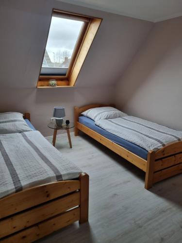 1 dormitorio con 2 camas y ventana en Haus Rose en Nortorf