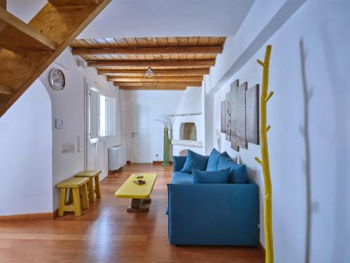 a living room with a blue couch and a table at Retreat Paros - The Happy Apartment in Parikia