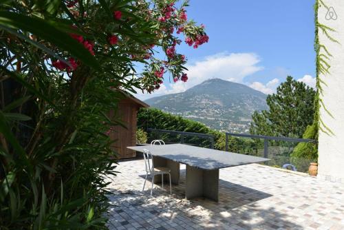 uma mesa de piquenique com vista para uma montanha em Villa with unique & breathtaking view over Sea, Monte-Carlo, Italy & Alps em La Turbie