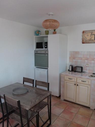 a kitchen with a table and a white refrigerator at Luciana in La Croix-Valmer