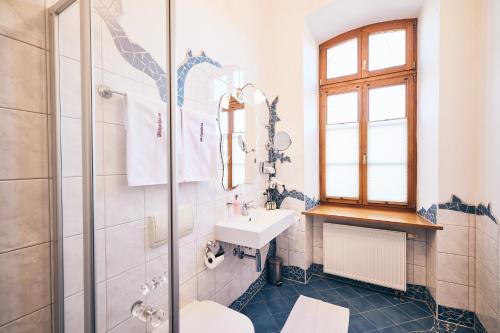 y baño blanco con lavabo y ducha. en Hotel & Restaurant Waldschloss, en Passau