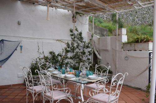 uma mesa e cadeiras num pátio com uma árvore de Natal em La Caletta Praiano Smart working in totale relax immersi nella natura incontaminata em Praiano