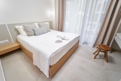 a bedroom with a bed with white sheets and a window at Celine's Rose in Skala Potamias