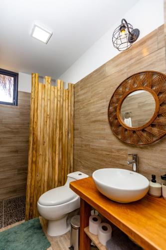 a bathroom with a white sink and a toilet at Casa Wiro - Casa de Playa en Vichayito by WiroHouse in Vichayito