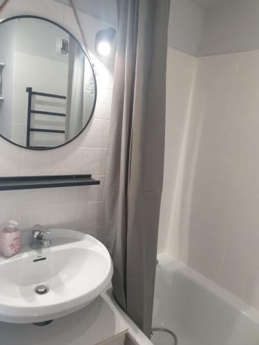 une salle de bain blanche avec un lavabo et un miroir dans l'établissement Studio meublé cap d Agde avec tres belle vue sur le port, au Cap d'Agde