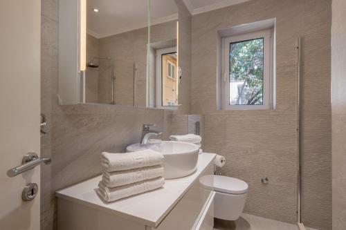 La salle de bains est pourvue d'un lavabo, de toilettes et d'un miroir. dans l'établissement Apartment Banje Beach 3, à Dubrovnik