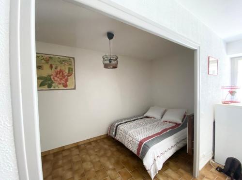 ein Schlafzimmer mit einem Bett in der Ecke eines Zimmers in der Unterkunft Studio en rez-de-chaussée tout équipé in Jullianges