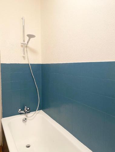 ein Badezimmer mit einem weißen Waschbecken und einer blauen Wand in der Unterkunft Studio en rez-de-chaussée tout équipé in Jullianges