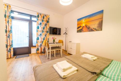 a bedroom with two beds and a table and a window at Pokoje u Matiego in Mikołajki